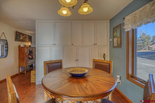 dining area with dark hardwood / wood-style floors and a textured ceiling