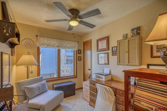 carpeted office with ceiling fan and a textured ceiling