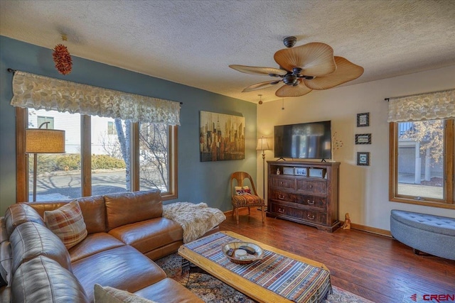 living room with ceiling fan, dark hardwood / wood-style floors, and a textured ceiling