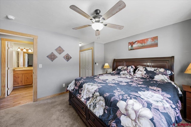 carpeted bedroom with ceiling fan, connected bathroom, sink, and a closet