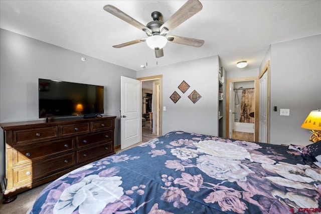 bedroom with ceiling fan, carpet flooring, and ensuite bath