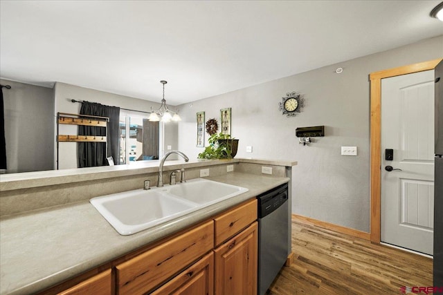 kitchen featuring sink, dark wood-type flooring, hanging light fixtures, and dishwasher