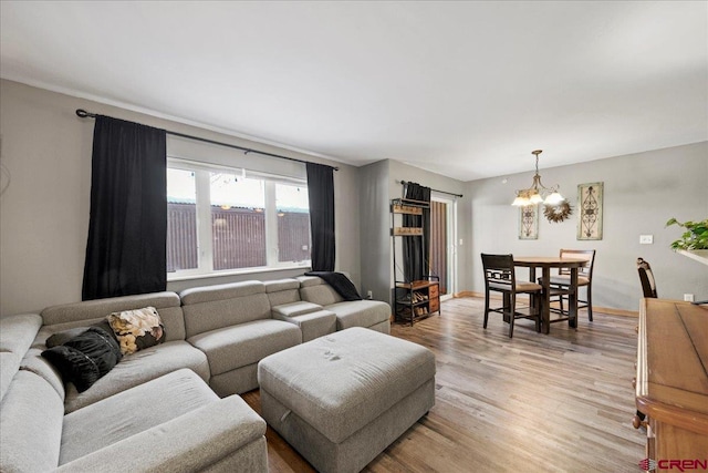 living room with a notable chandelier and light hardwood / wood-style floors