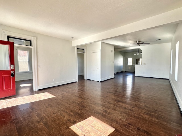 unfurnished living room featuring dark hardwood / wood-style floors and ceiling fan