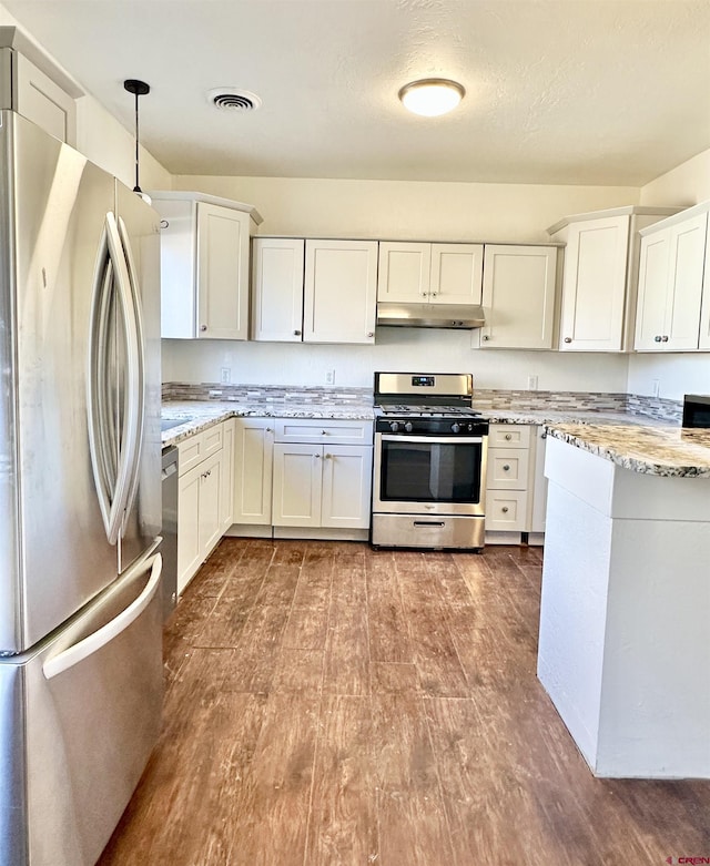 kitchen with hanging light fixtures, stainless steel appliances, and white cabinets