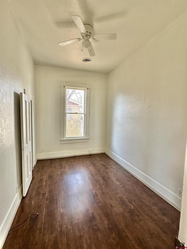 empty room with ceiling fan and dark hardwood / wood-style floors