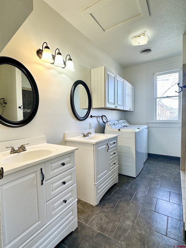 interior space featuring sink, a textured ceiling, cabinets, and independent washer and dryer