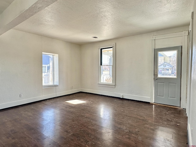 foyer featuring dark wood-type flooring and a textured ceiling