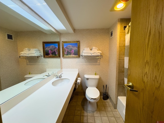 full bathroom with vanity, tile patterned floors, washtub / shower combination, and toilet