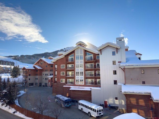 snow covered property featuring a mountain view and a garage