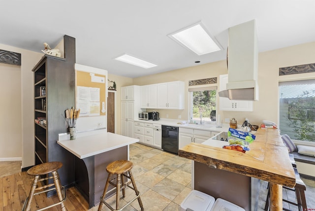 kitchen featuring a breakfast bar, black dishwasher, kitchen peninsula, and white cabinets