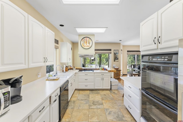 kitchen featuring sink, kitchen peninsula, white cabinets, and black appliances