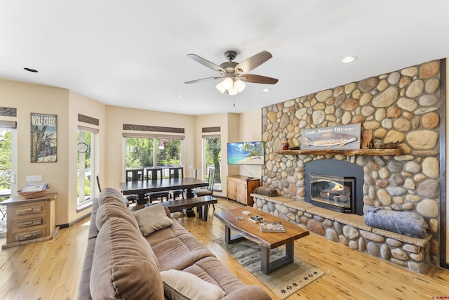 living room with a fireplace, light hardwood / wood-style flooring, and ceiling fan