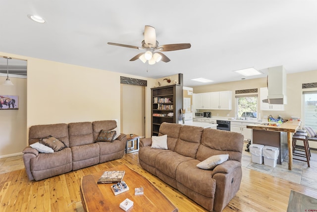 living room with light hardwood / wood-style floors and ceiling fan