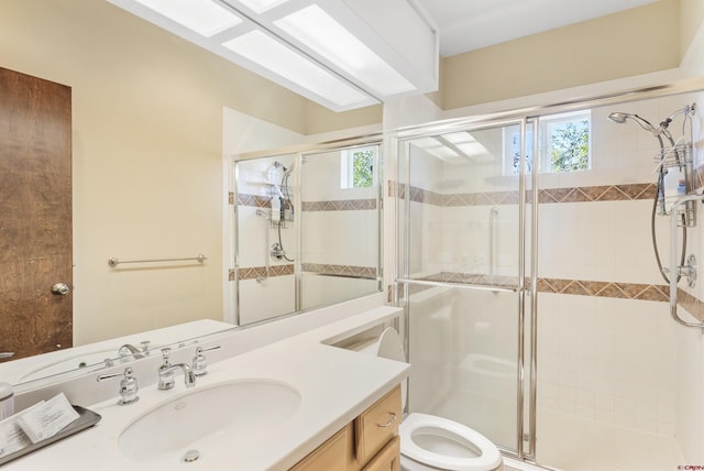 bathroom featuring walk in shower, a healthy amount of sunlight, toilet, and vanity