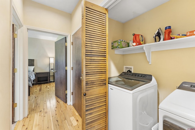 laundry room featuring separate washer and dryer and light hardwood / wood-style flooring