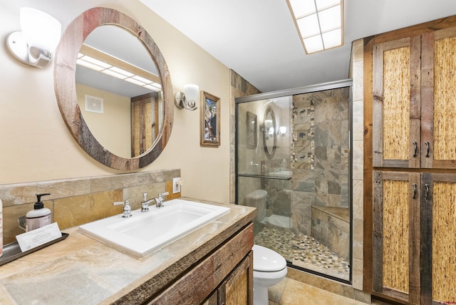 bathroom featuring an enclosed shower, vanity, and toilet