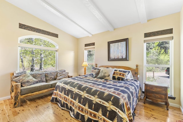 bedroom featuring wood-type flooring and vaulted ceiling with beams