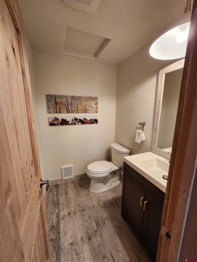 bathroom featuring vanity, wood-type flooring, and toilet