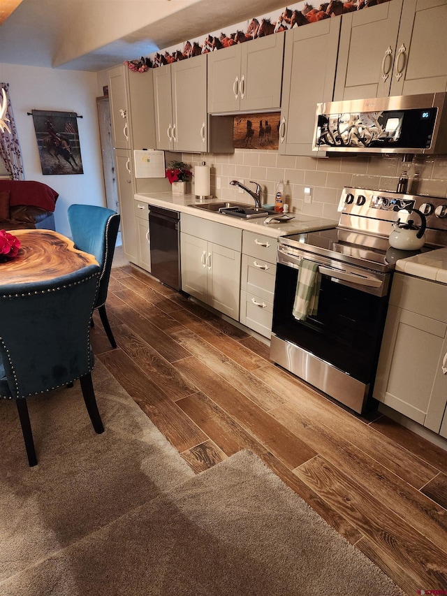 kitchen with dark wood-type flooring, dishwasher, extractor fan, stainless steel electric range oven, and decorative backsplash