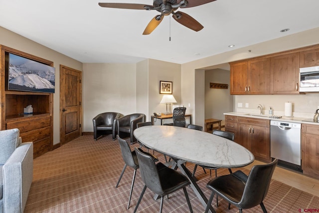 carpeted dining space with sink and ceiling fan