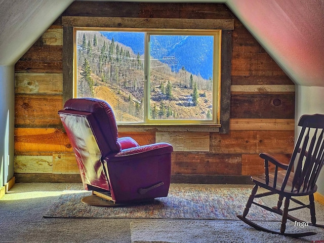 living area featuring lofted ceiling, wooden walls, and a textured ceiling