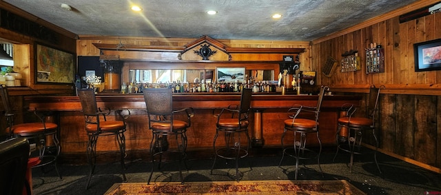 bar featuring ornamental molding and wood walls