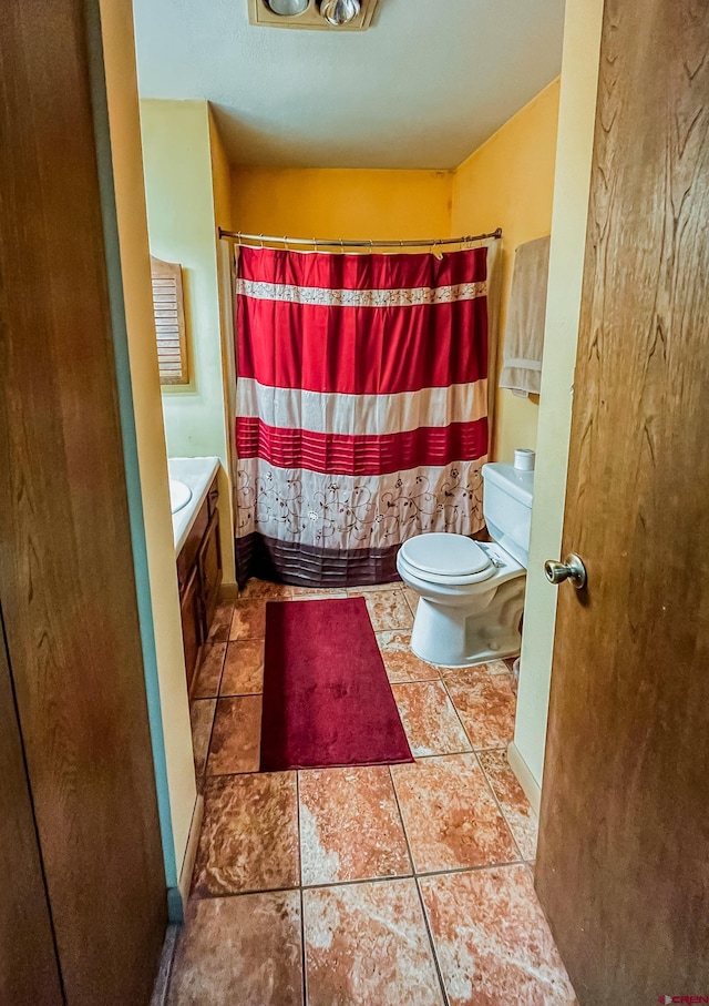 bathroom featuring vanity, curtained shower, tile patterned floors, and toilet