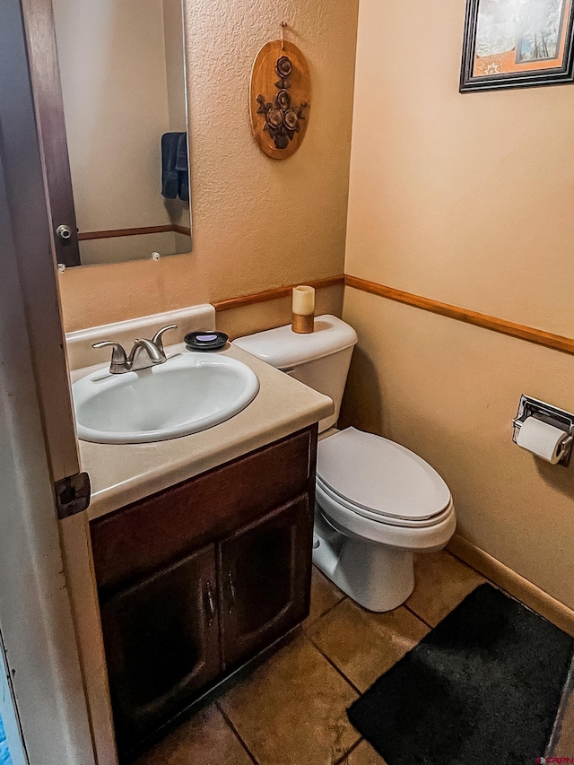 bathroom featuring tile patterned flooring, vanity, and toilet