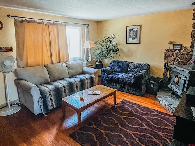 living room with a wood stove, hardwood / wood-style floors, and a textured ceiling