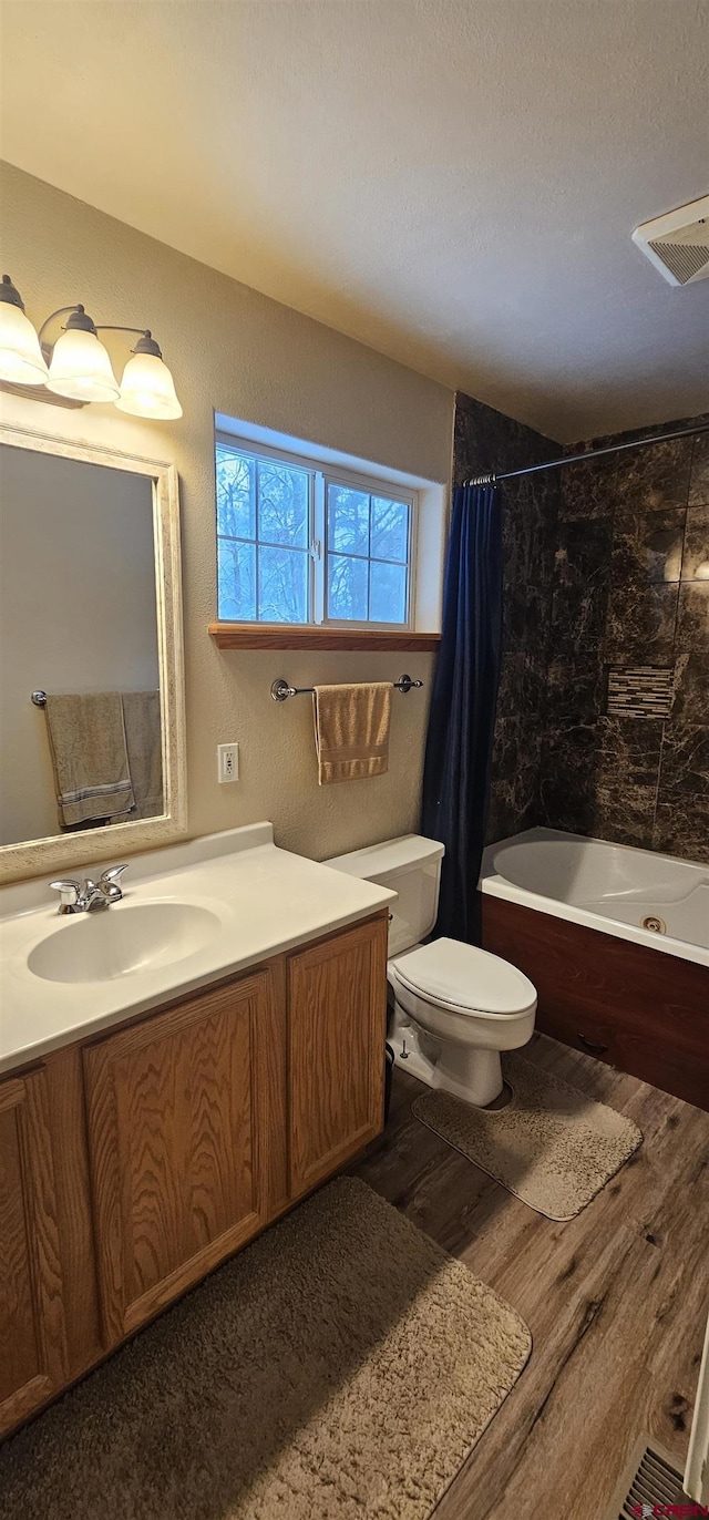 full bathroom featuring vanity, wood-type flooring, shower / tub combo, and toilet