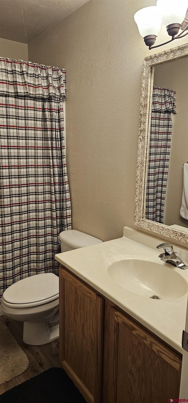 bathroom featuring hardwood / wood-style flooring, vanity, a textured ceiling, and toilet