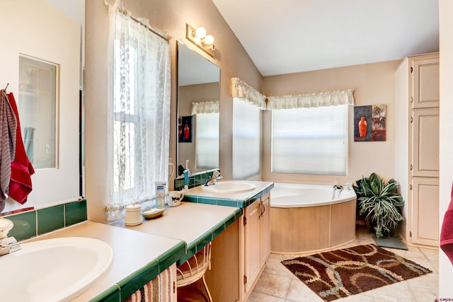 bathroom featuring tile patterned flooring, a bathing tub, lofted ceiling, and a wealth of natural light