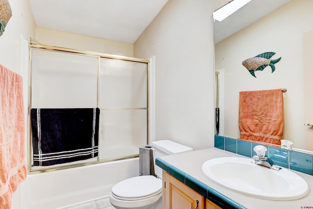 full bathroom featuring vanity, combined bath / shower with glass door, and toilet