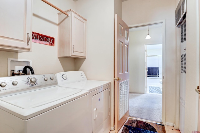 clothes washing area with washing machine and dryer and cabinets