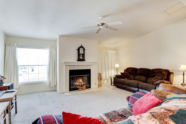 living room with ceiling fan, carpet floors, and a tile fireplace