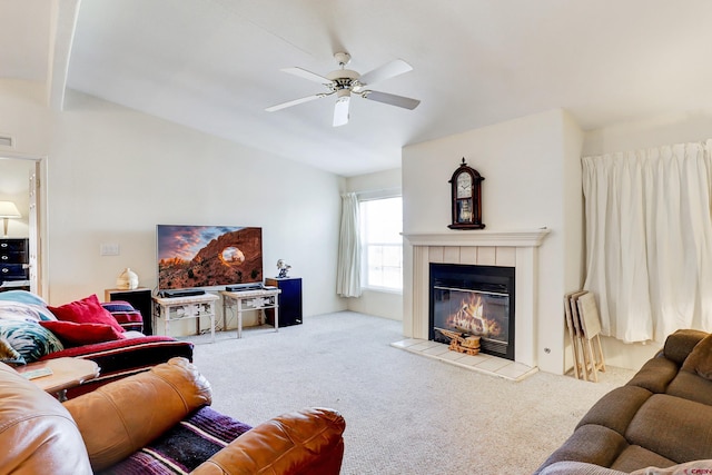 living room featuring a tile fireplace, lofted ceiling, carpet floors, and ceiling fan