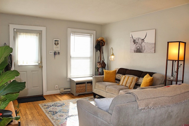 living room with a wealth of natural light, light hardwood / wood-style floors, and a baseboard radiator