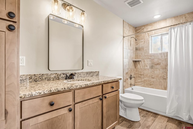 full bathroom featuring shower / tub combo, hardwood / wood-style floors, vanity, and toilet