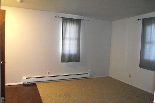 unfurnished room with a baseboard radiator and dark hardwood / wood-style floors