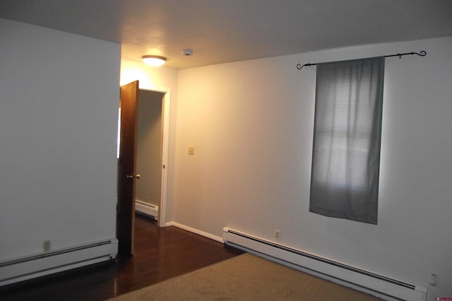 spare room with a baseboard radiator and dark wood-type flooring