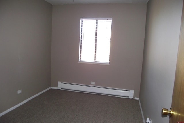 unfurnished room with baseboard heating and dark carpet