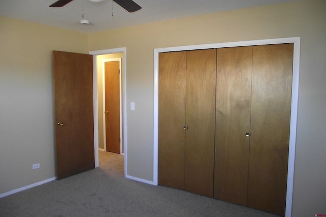 unfurnished bedroom with light colored carpet, a closet, and ceiling fan