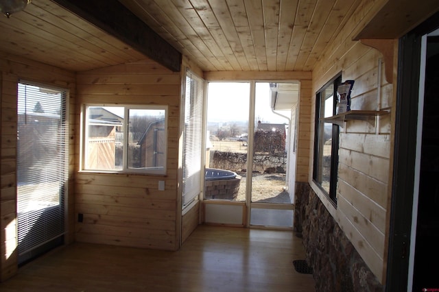 unfurnished sunroom with vaulted ceiling, wooden ceiling, and a healthy amount of sunlight