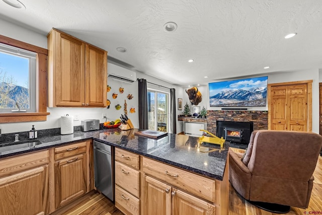 kitchen with dark stone countertops, kitchen peninsula, and an AC wall unit