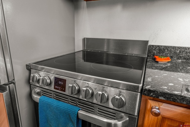 interior details with dark stone countertops and electric stove