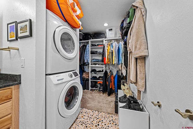 laundry area with stacked washer and dryer and light colored carpet