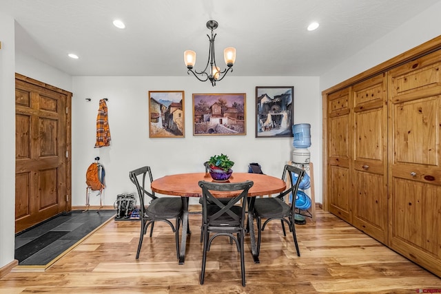 dining space featuring hardwood / wood-style floors and a notable chandelier