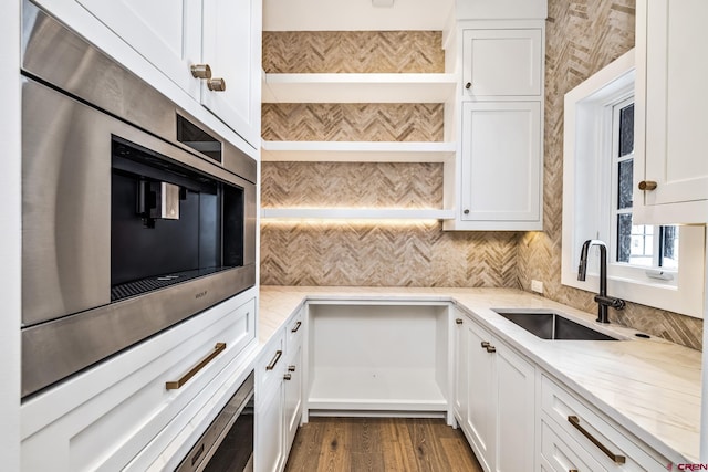 kitchen featuring white cabinetry, sink, and light stone counters