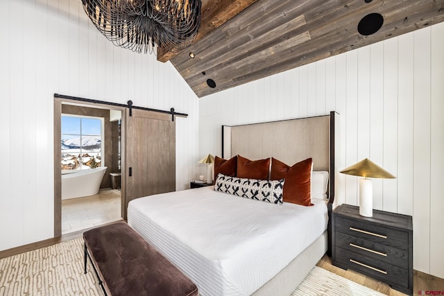 bedroom featuring a barn door and lofted ceiling